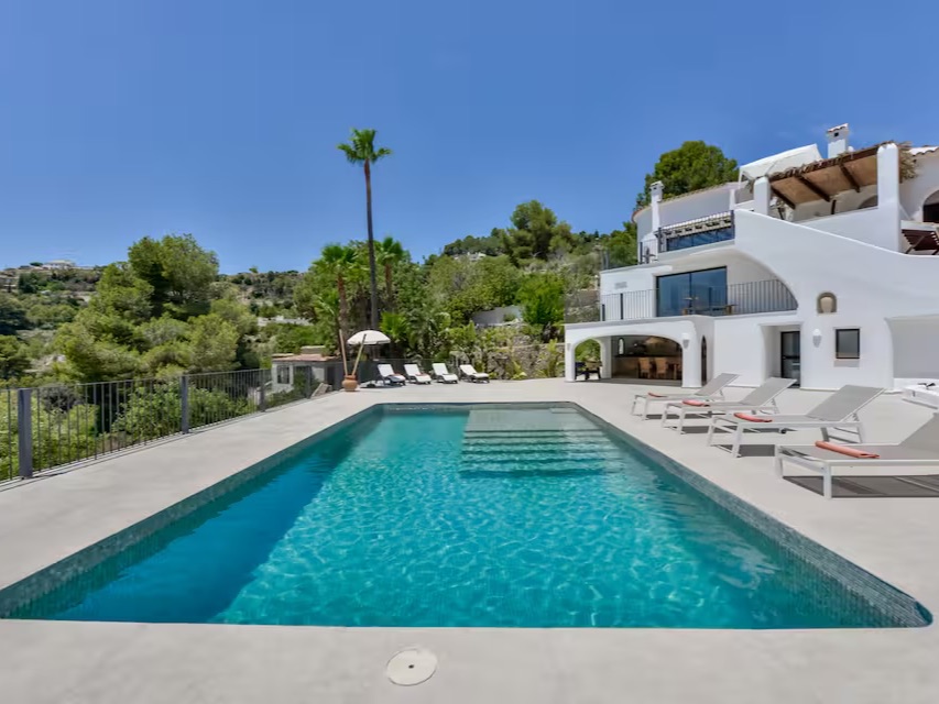 Der Pool mit Blick auf die weiße Villa