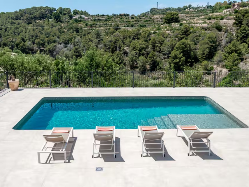 Pool mit Sonnenliegen in der Nachmittagssonne