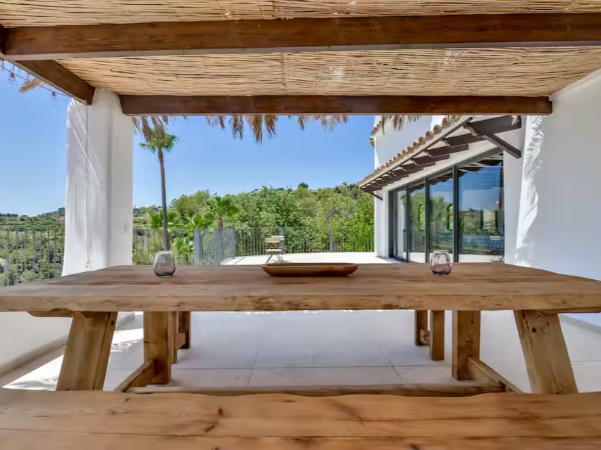 Überdachte Terrasse mit langer Holztafel